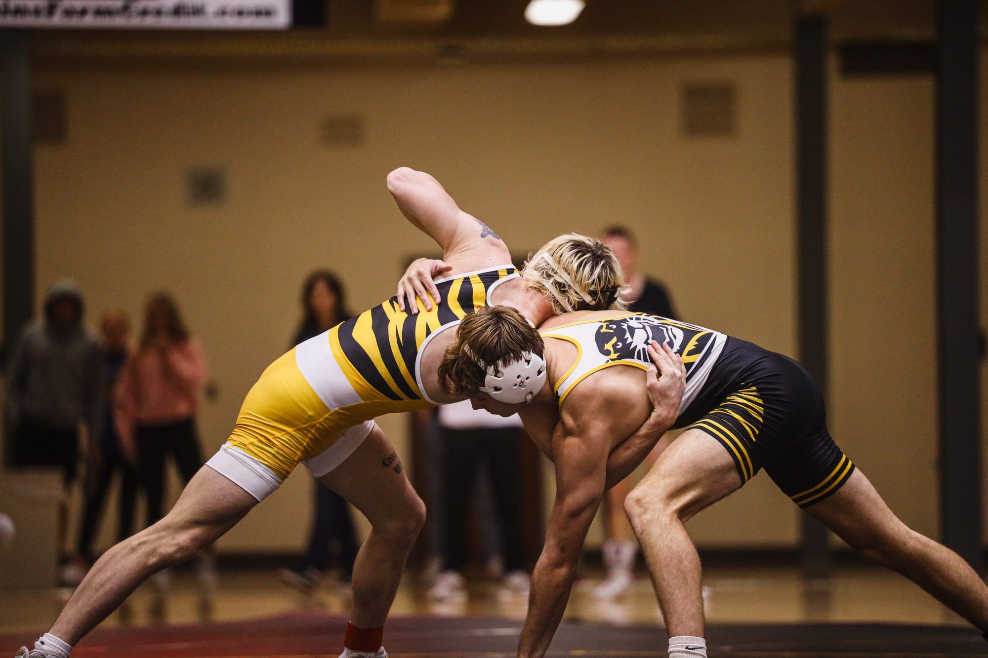 Two FHSU wrestlers locked up on the mat during a dual, shot from low and close